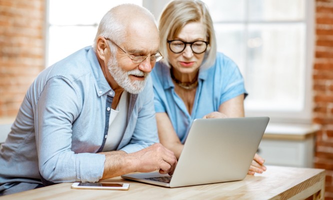 Two seniors in front of a laptop